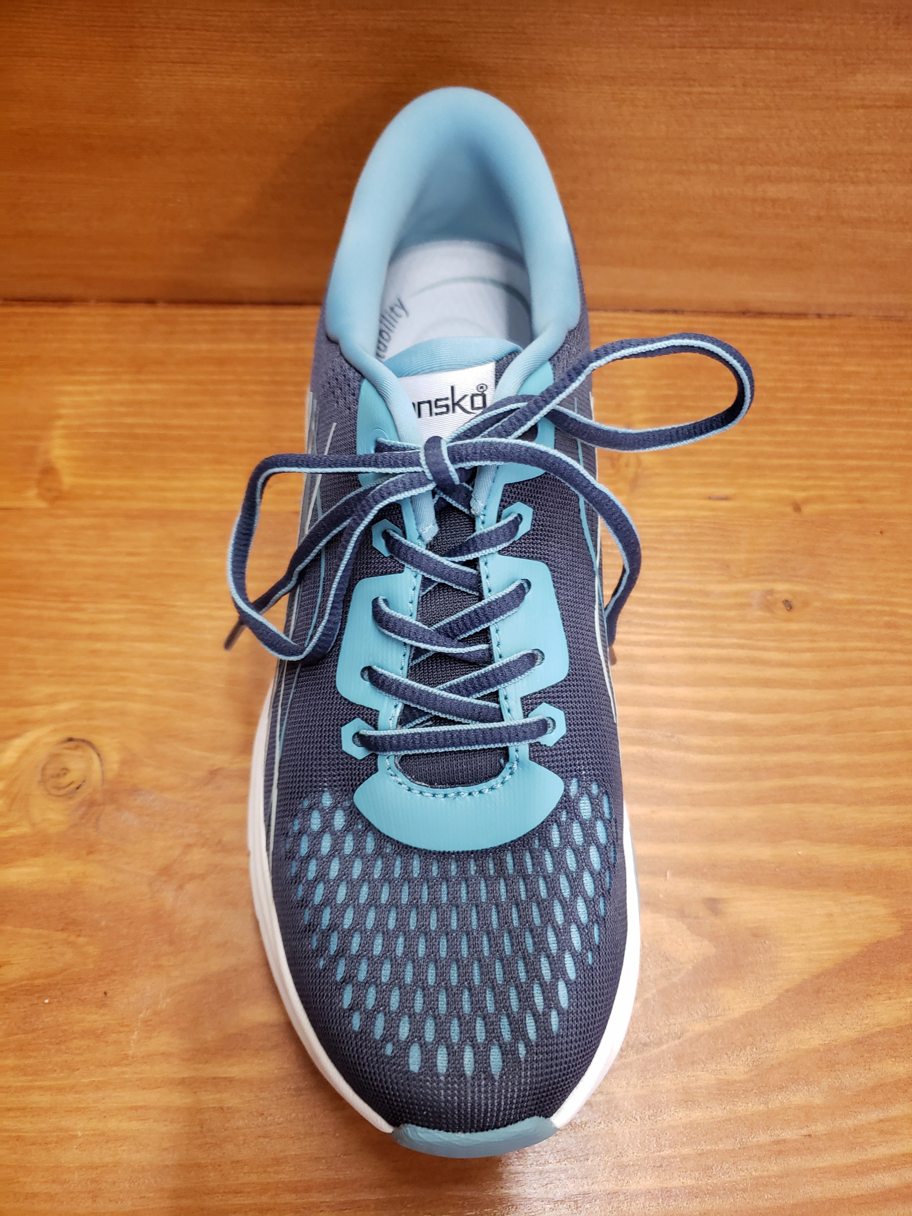 Dansko Pace Navy Mesh running in a wooden bridge area shoes